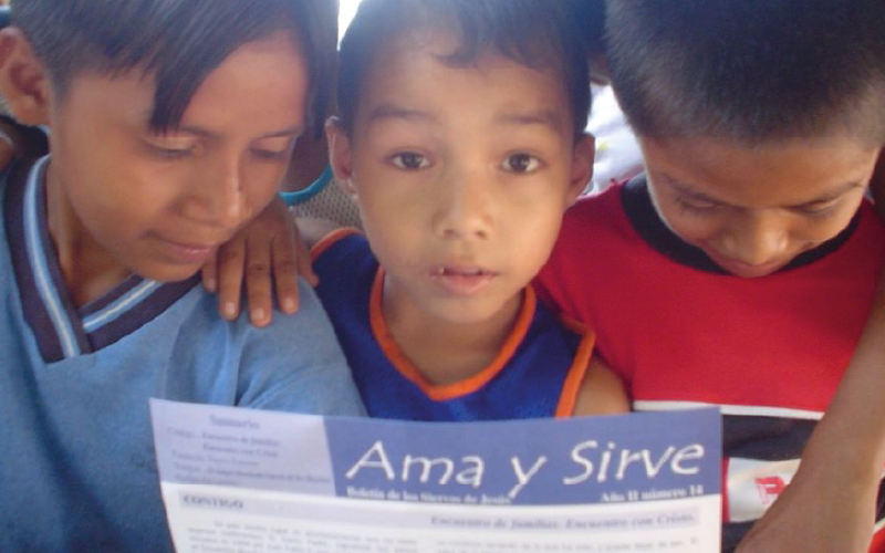Niños en Honduras leyendo el Boletín Ama y Sirve