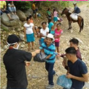 Sacerdote repartiendo comida en poblado pobre en Honduras.